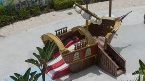 Zona de juegos temática pirata con toboganes y una estructura con forma de barco.