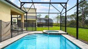 Una piscina con hidromasaje, rodeada por un porche cubierto con vista a una casa y árboles.