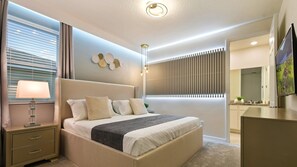 Relax in a spacious bedroom with a large bed, bedside tables, and a decorative wall piece.