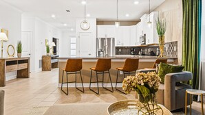 A modern kitchen with white cabinets, stainless steel appliances, and a central island. - Last Minute Disney! Private Pool, Hot Tub & Themed Bedrooms. Book Now! #79721 (Orlando)