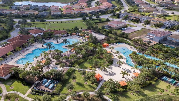 Vista aerea di un resort con diverse piscine, palme e diversi edifici residenziali.