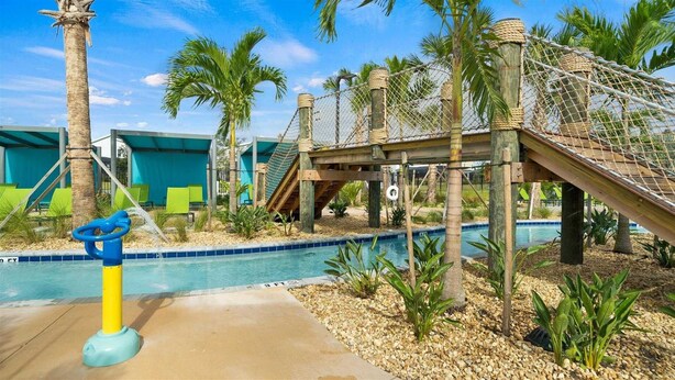 A pool area with a rope bridge, palm trees, and a lifebuoy. - Last Minute Disney! Private Pool, Hot Tub & Themed Bedrooms. Book Now! #89755 (Orlando)
