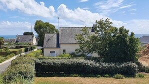 Een woonwijk met huizen, een verzorgde tuin en een helder uitzicht op zee.