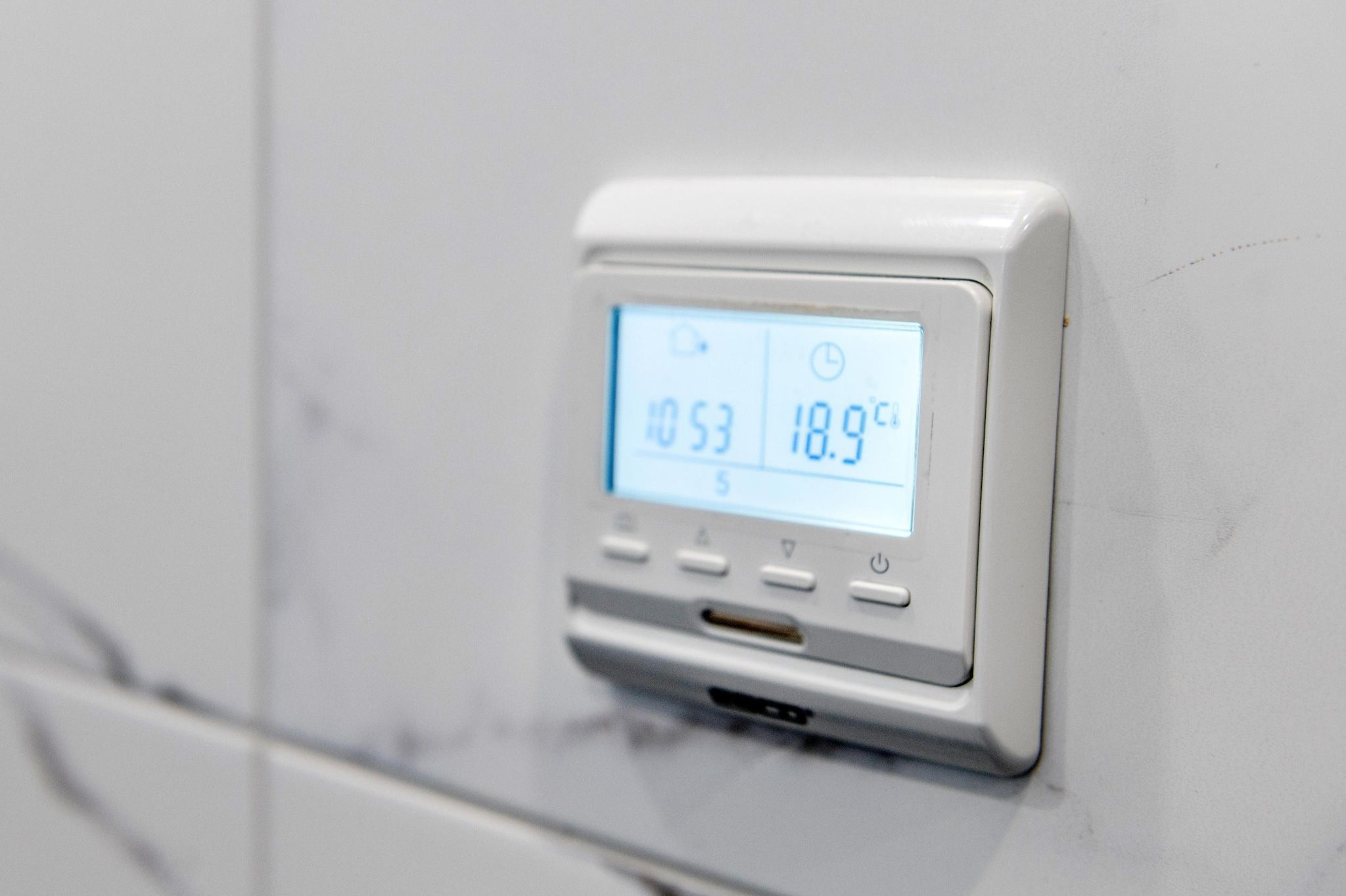 Un thermostat numérique fixé au mur affiche une température de 18,9 °C et un taux d’humidité de 53 %.