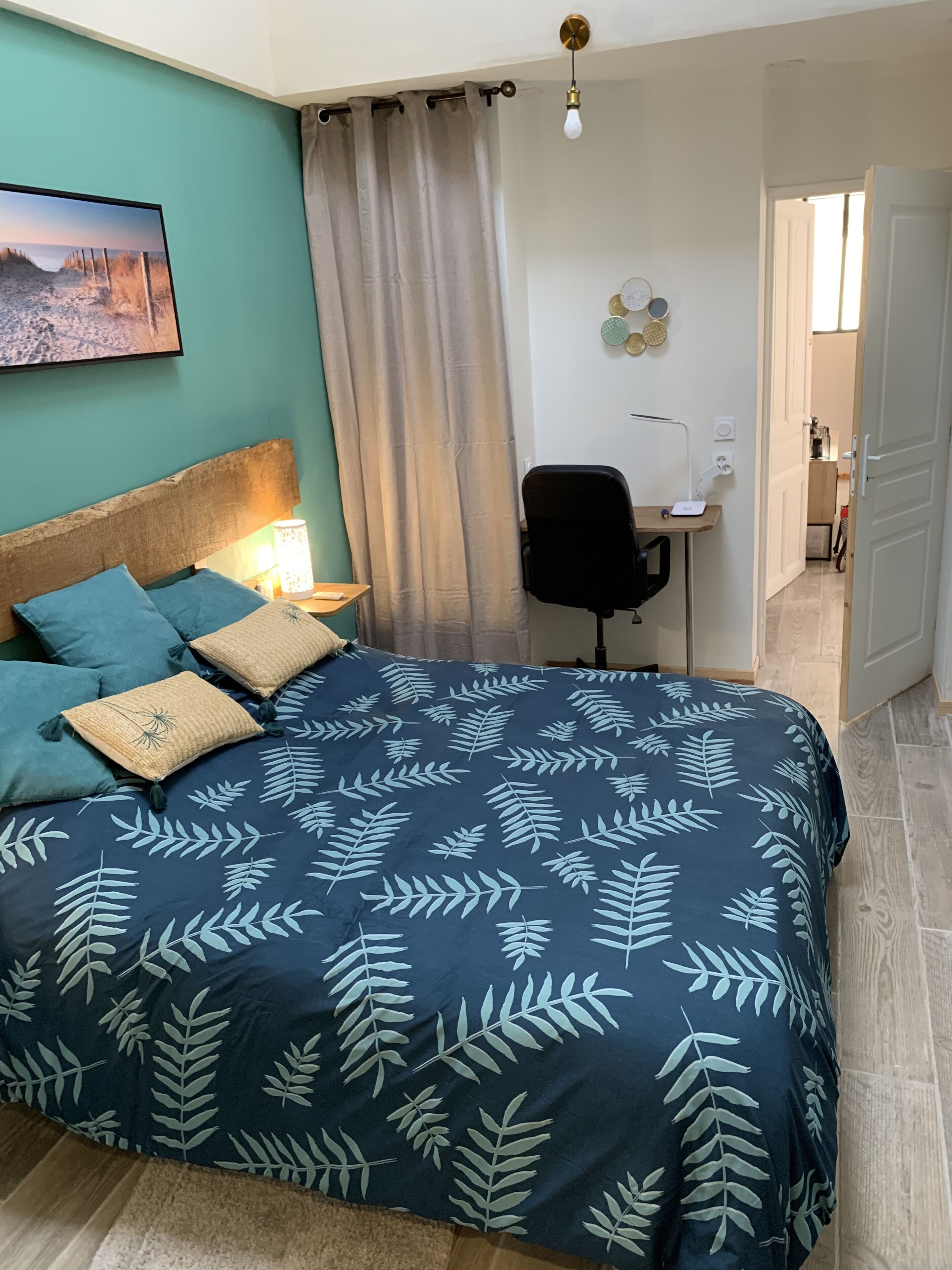 A bedroom with a bed, a desk, and a chair.