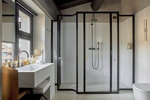 Un baño moderno con un lavamanos grande, espejo y cabina de ducha.