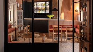 Un interno moderno con un'area bar, posti a sedere e una parete divisoria in vetro.