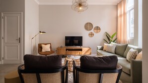 A modern living room with a sofa, a coffee table, and a TV stand.