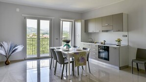 Eine moderne Küche mit Essbereich, großen Fenstern und Blick ins Freie.