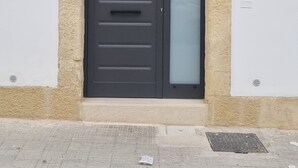 Una porta con parete beige strutturata, una porta scura e un vetro.