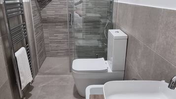 Een douche, een haardroger, een bidet, handdoeken