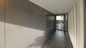 Ein moderner Flur mit grauer Wand und einer Reihe von Schließfächern.