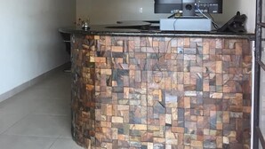 Une cuisine avec un pare-feu en pierre, un téléviseur à écran plat et un luminaire encastré au plafond.