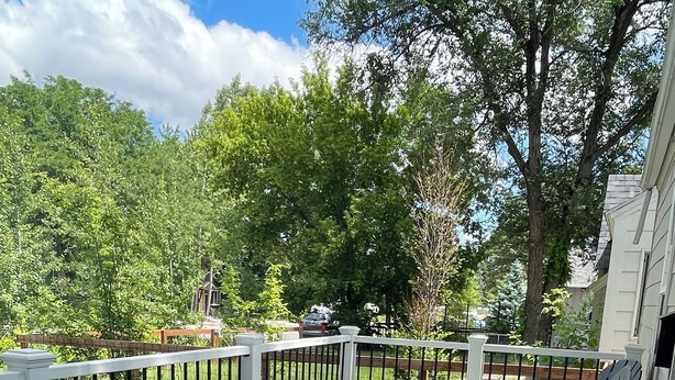 A wooden deck with white railings and two lounge chairs. - New! Renovated 2BD Home in Downtown (Billings)