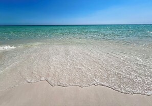 Una playa con agua turquesa cristalina y una orilla arenosa.
