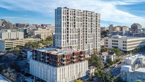 A high-rise building with a modern design, surrounded by other buildings and a clear sky. - 2BD/Austin - Full Kitchen, W/D, Balcony, Fire Pit! (Austin)