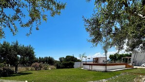 A hammock on a gravel surface with a grassy area and trees in the background. - VILLA Indipendente con Piscina privata e accesso al mare. (Puglia)