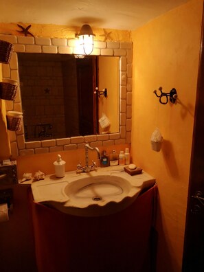 A bathroom with a white sink, a mirror, and a towel rack.