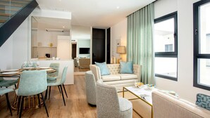 A modern living room with a sofa, armchairs, and a dining area with a table and chairs. - Genteel Home Betis XXVI (Seville)