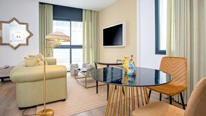 Uma sala de estar moderna com sofá, mesa de centro, TV e mesa de jantar com cadeiras.