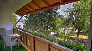 A balcony with a wooden railing, a table, and two chairs. - 87452 Altusried district Frauenzell, near Center Parcs Leutkirch im Allgäu (Altusried)