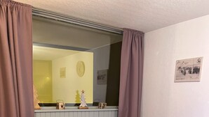 A room with a bed, a mirror, a small Christmas tree, and a framed photo on the wall. - 7 Couchages + Bébé, sur les Pistes + Parking (Besse-et-Saint-Anastaise)