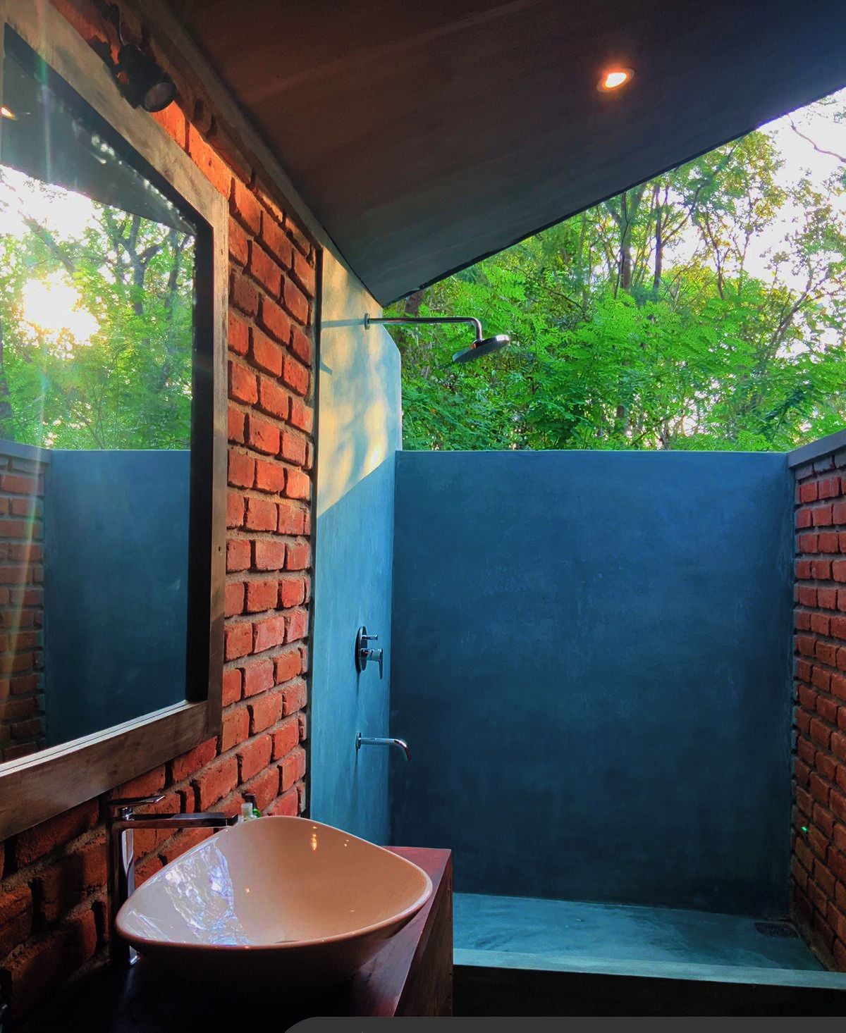 Une salle de bain avec une grande fenêtre, un lavabo et une douche.