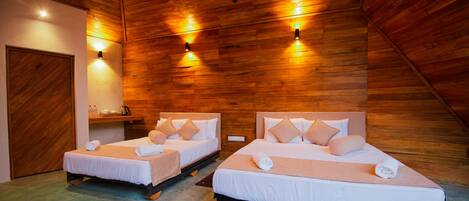 Two single beds with wooden headboards and beige bedding in a room with wooden walls and ceiling.