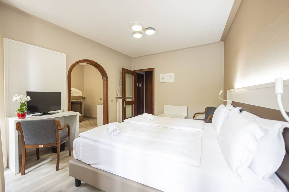 Une chambre d’hôtel équipée d’un lit, d’un bureau, d’une chaise et d’un téléviseur.