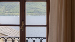 A window with a view of a lake and hills. - LVG Hotel Collection - Il Portico (Cannobio)