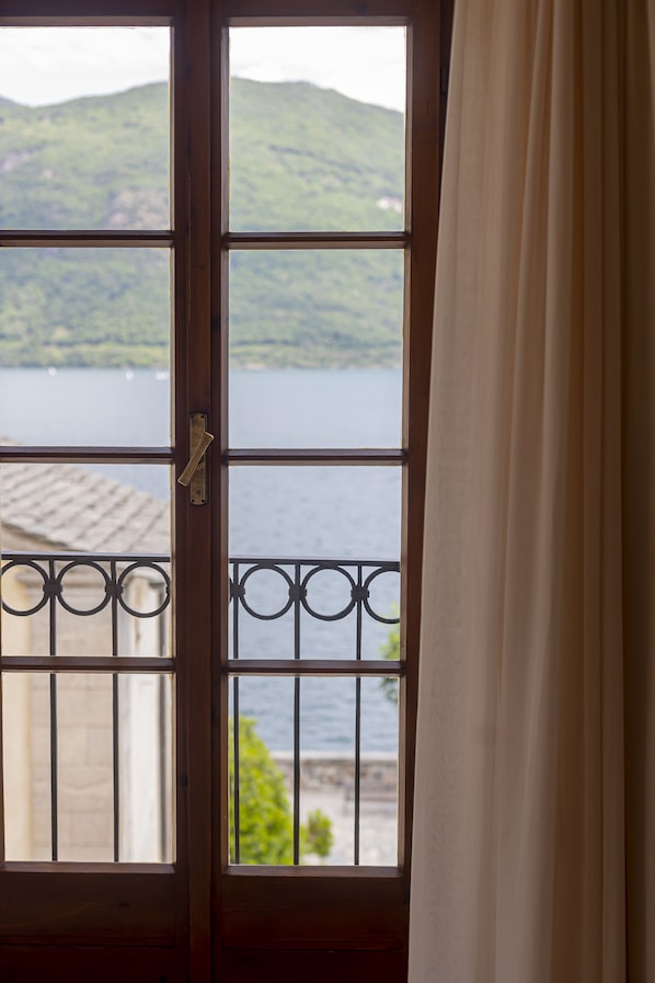 A window with a view of a lake and hills. - LVG Hotel Collection - Il Portico (Cannobio)