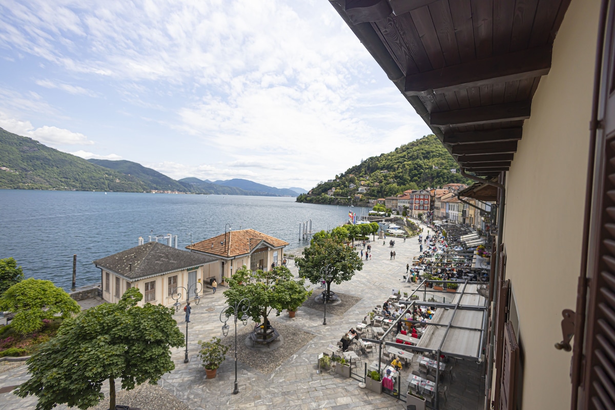 Un paseo marítimo junto al lago, con tiendas y cafés, adoquinado de piedra y árboles.