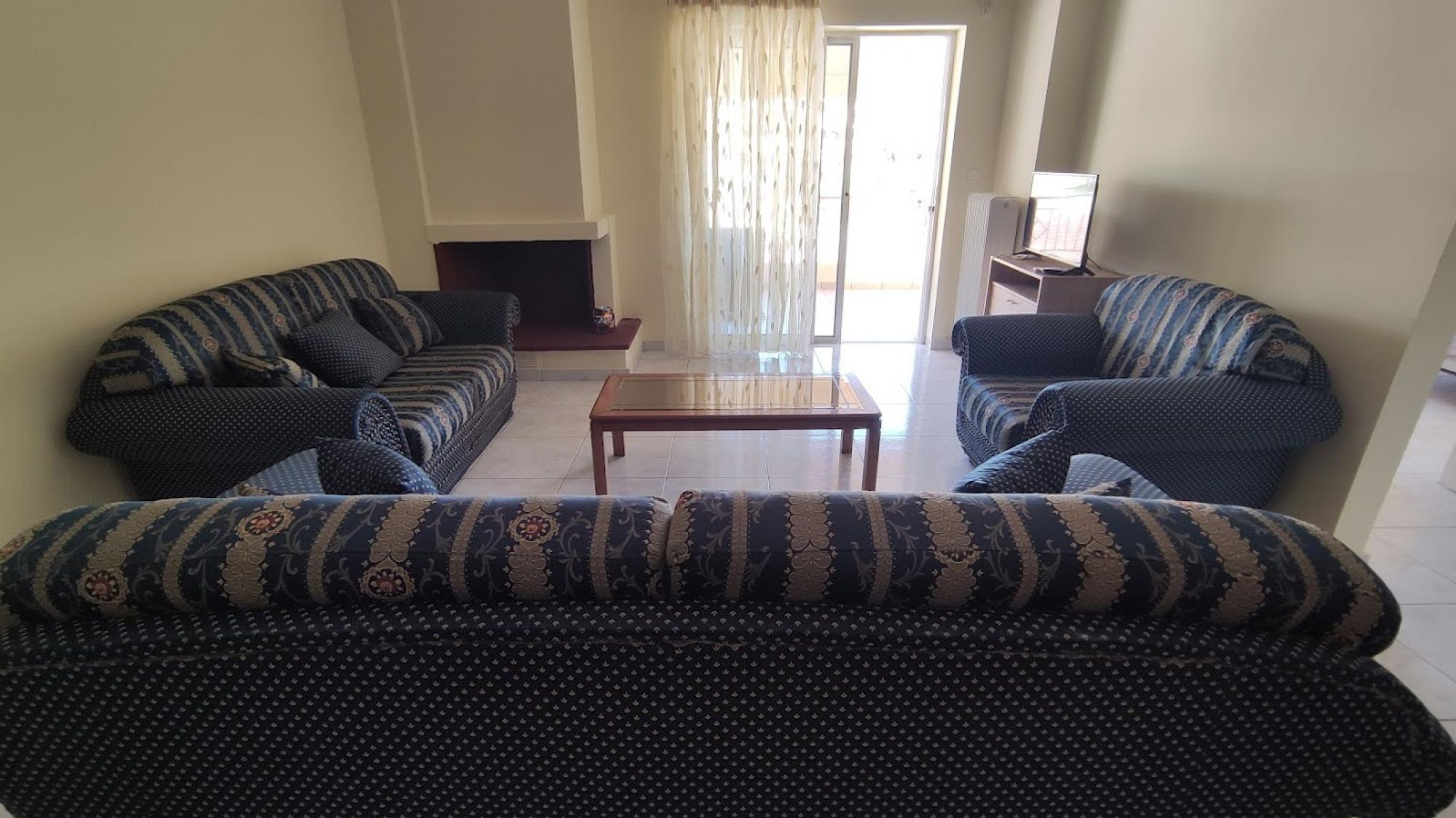 A living room with two sofas, a coffee table, and a television on a stand.