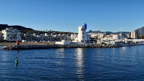 A coastal town with a prominent lighthouse, marina, and residential buildings. - Via Celere 2405 Beautiful apartment with seaview (Casares)