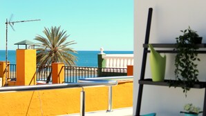 A balcony with a view of the sea, a palm tree, and a shelf with plants. - Estropada 1, detached apartment in Pedregalejo, Malaga, with sea views (Málaga)