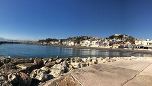 A coastal town with a rocky shoreline, buildings along the beach, and a clear blue sky. - Estropada 1, detached apartment in Pedregalejo, Malaga, with sea views (Málaga)