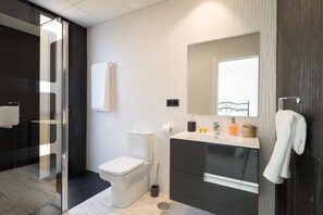 A modern bathroom with a glass shower enclosure, a toilet, a sink with a mirror, and a towel rack. - Estropada 1, detached apartment in Pedregalejo, Malaga, with sea views (Málaga)