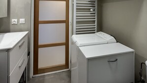 Une salle de bain moderne et compacte, dotée d’un lavabo blanc, de toilettes et d’un meuble encastré.