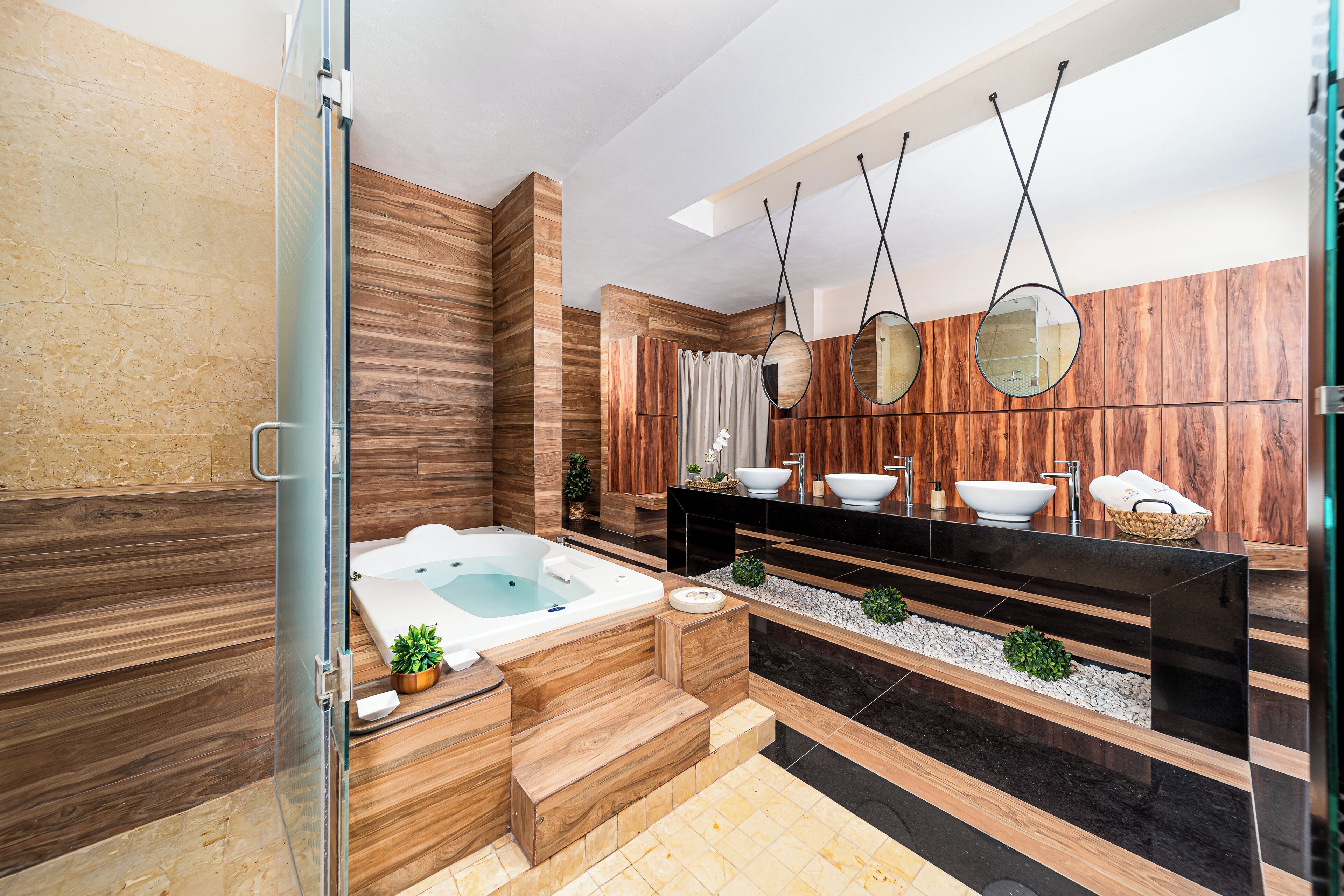 A modern bathroom with a wooden vanity, a freestanding bathtub, and a large mirror.