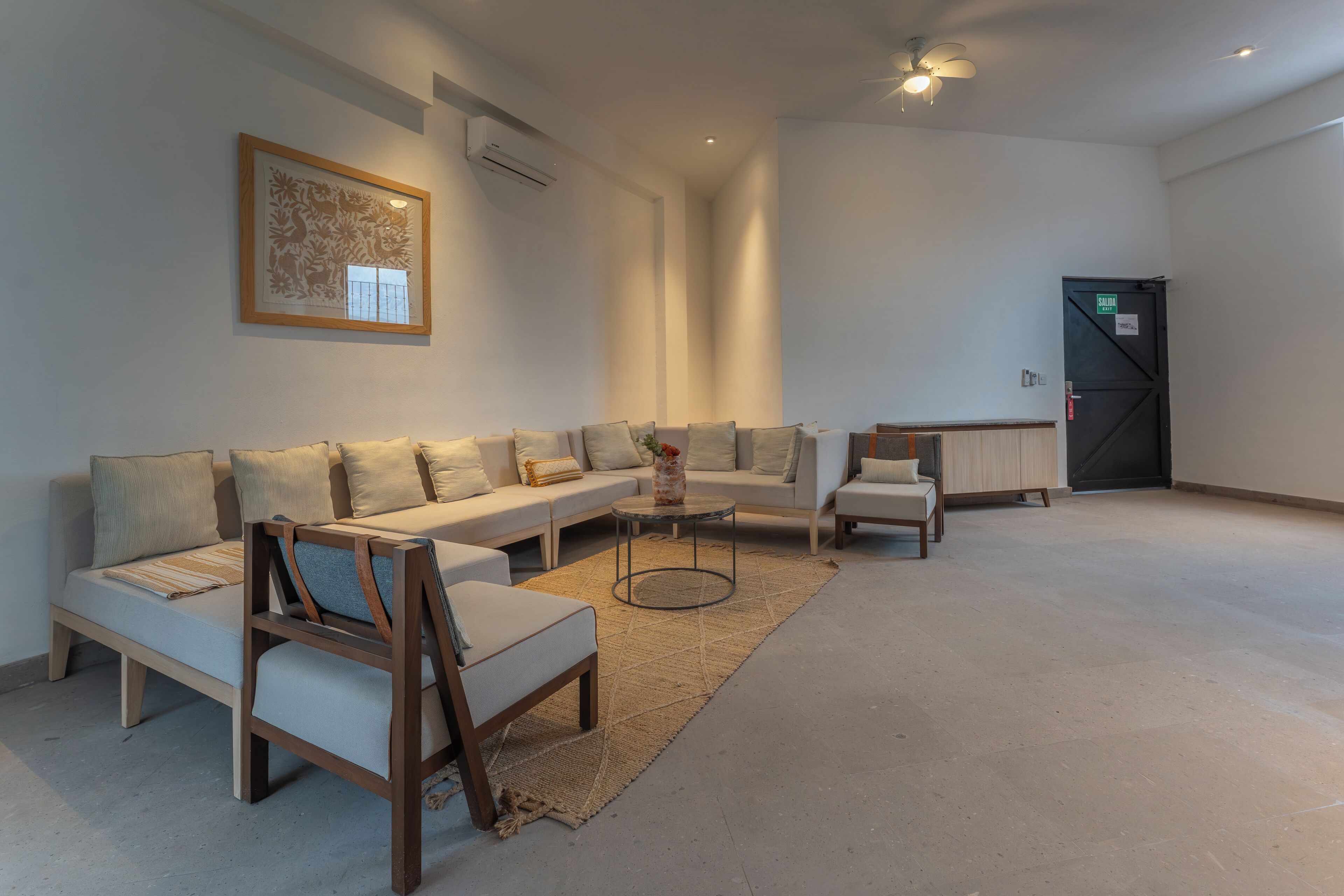 A spacious living area with a sofa set, a coffee table, and a small wooden chair.