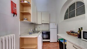 A compact kitchen with white cabinets, a built-in oven, and a window. - Neri 23 in Firenze With 3 Bedrooms and 2 Bathrooms (Florence)