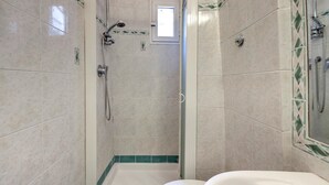 A bathroom with a shower, toilet, and sink.