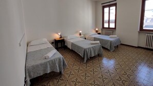 A room with three single beds, a small table, and a window with a view. - Agnolo 73 IV in Firenze (Florence)
