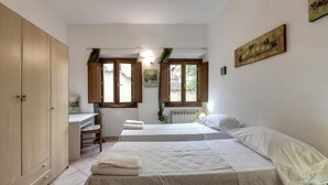 A bedroom with two beds, a desk, and a wardrobe. - Sapiti 2 G in Firenze (Florence)