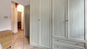 A room with a large wardrobe, a wooden dresser, and a tiled floor. - Sapiti 2 G in Firenze (Florence)