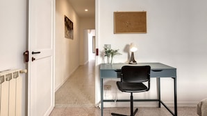 A room with a desk, chair, radiator, and a framed picture on the wall. - Greci 16 III in Firenze (Florence)