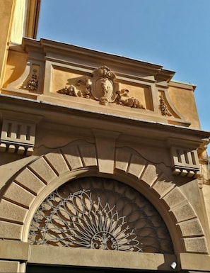 An ornate architectural detail with a decorative crest and a sunburst pattern. - Mezzo 46 in Firenze With 2 Bedrooms and 2 Bathrooms (Florence)