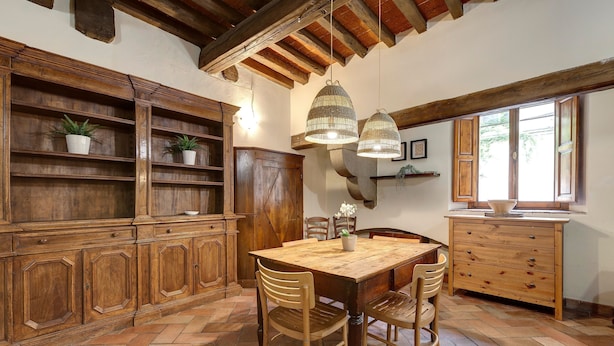 Une cuisine rustique avec des meubles en bois, un parquet en point de Hongrie et une grande table en bois.