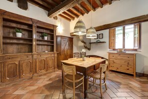 A rustic kitchen with wooden cabinets, a herringbone floor, and a large wooden table. - Anguillara 7 A in Firenze (Florence)