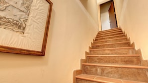 Un escalier avec une rampe en bois et un tableau encadré accroché au mur.